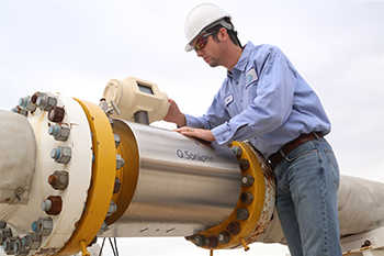 Man in hard hat calibrating an ultrasonic meter on a closed-loop facility