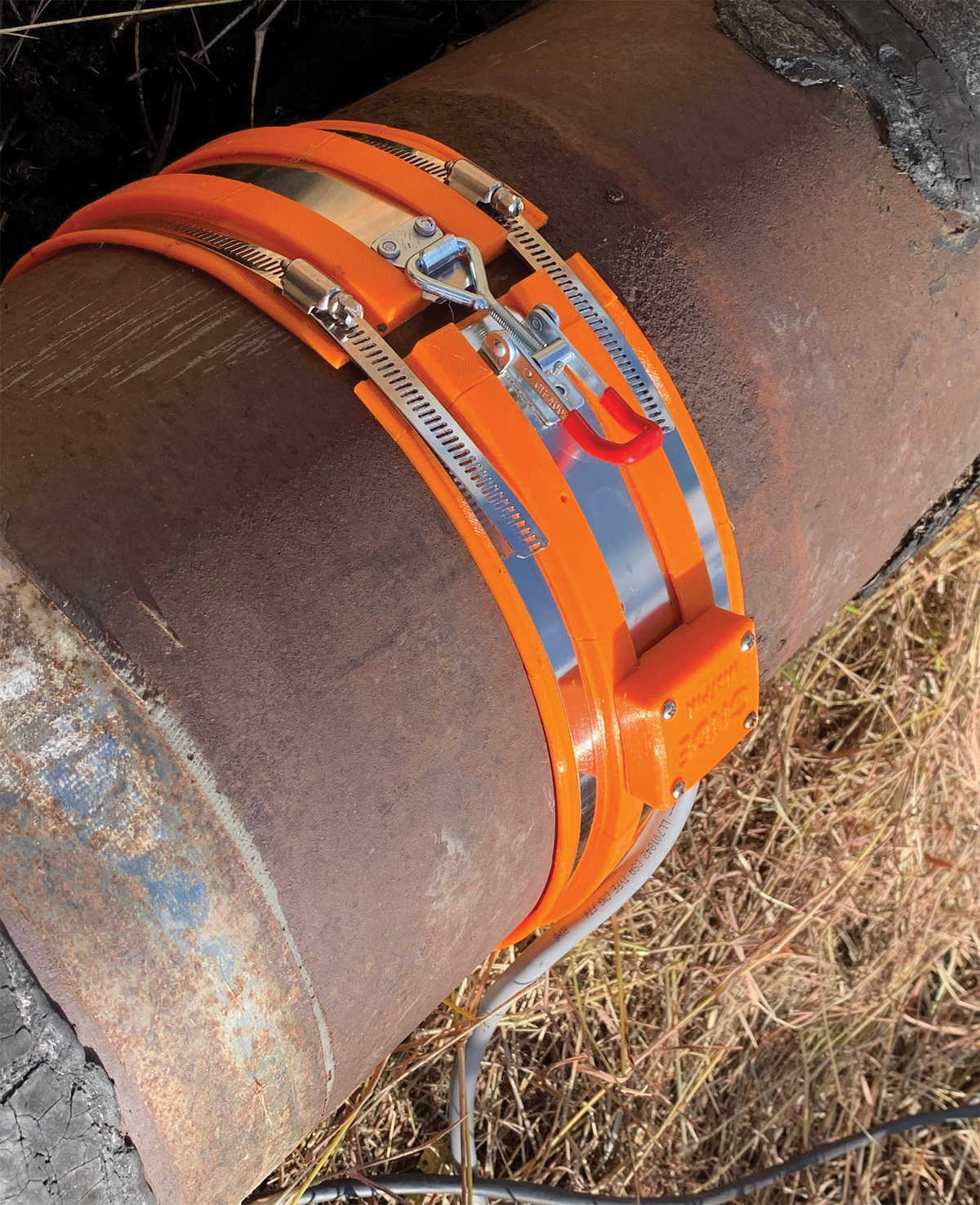 corroded pipe with orange Magnetostrictive Transducer collar around pipe