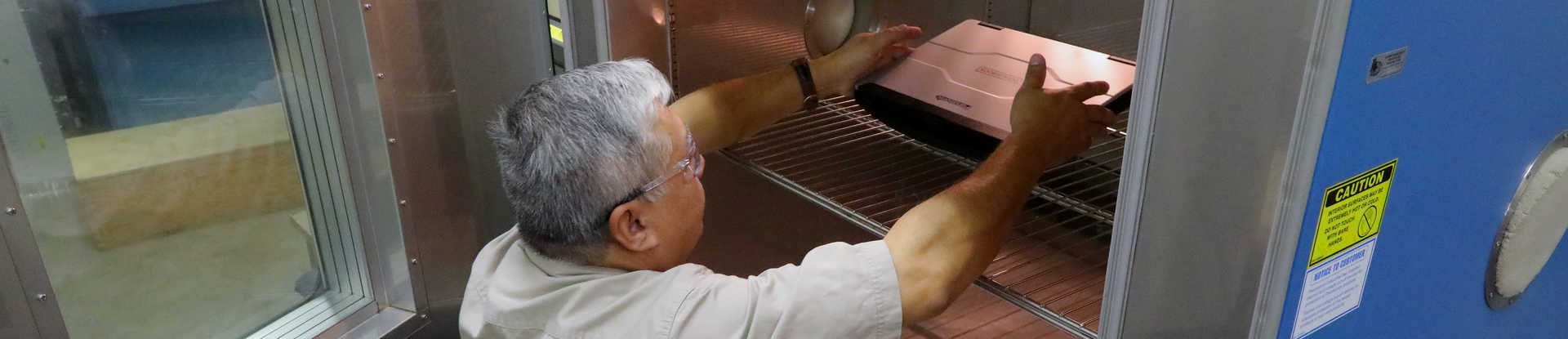 SwRI Principal Technician Michael Negrete places a laptop designed for rugged performance into a temperature/humidity chamber