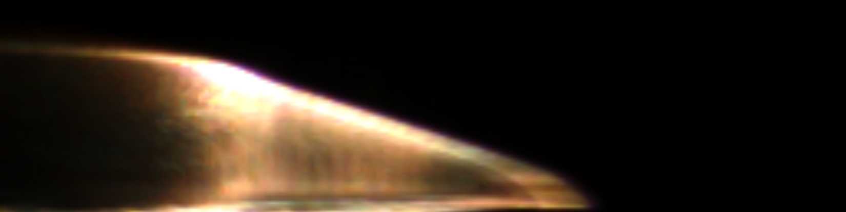 Conical flight body launched from a two-stage light gas gun flowing against a black background