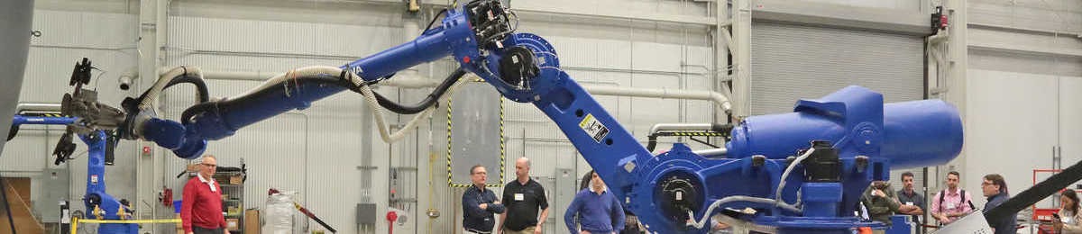 Engineers in a lab demonstrating a blue robot