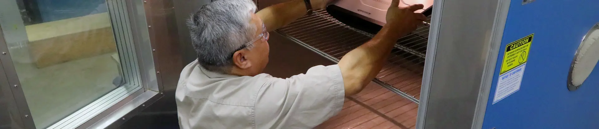 SwRI Principal Technician Michael Negrete places a laptop designed for rugged performance into a temperature/humidity chamber