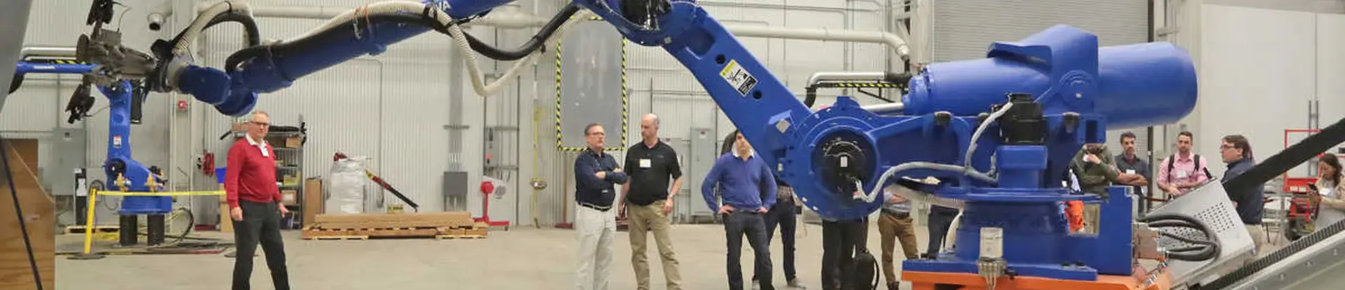 Engineers in a lab demonstrating a blue robot