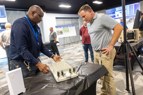 Two men looking at the new SwRI private 5G network at an open house