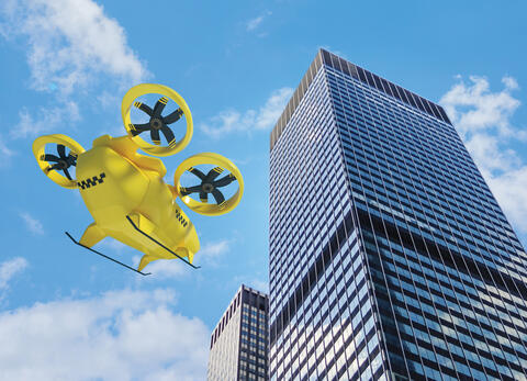 yellow air taxi heading toward multi-story building