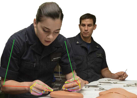 female and male military medical personnel working on a patient with markerless motion capture overlayed