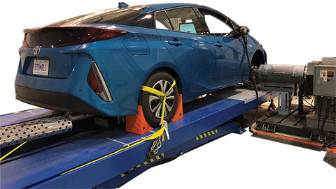 blue hybrid sedan connected to vehicle chassis dynamometer
