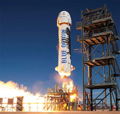 White rocket launching from a launch pad with blue sky in the background