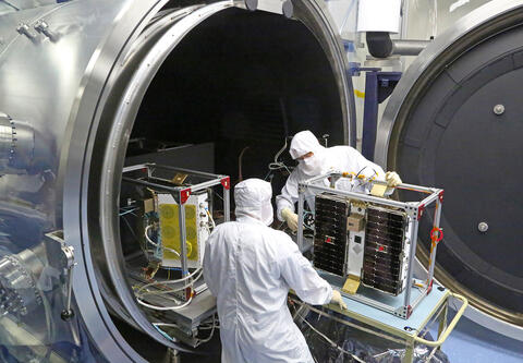 Two men performing extreme temperature testing  CYGNSS microsatellite constellation 