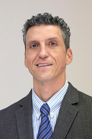 Professional portrait of Eloy Flores against a light background