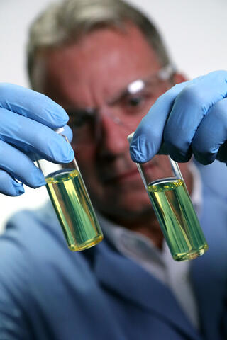 Engineer evaluating diesel fuel in two test tubes