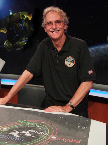 Portrait of John Spencer against a space backdrop