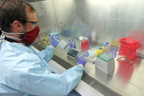 Scientist in a lab filling vials