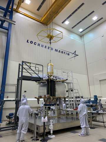 High bay clean room with Lucy spacecraft in center with team members in clean suits 