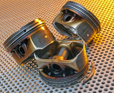 Image: modern automotive pistons showing ring land damage