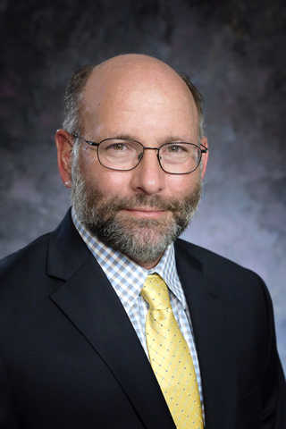 Professional headshot of Dr. Stephen Fuselier against a blue background