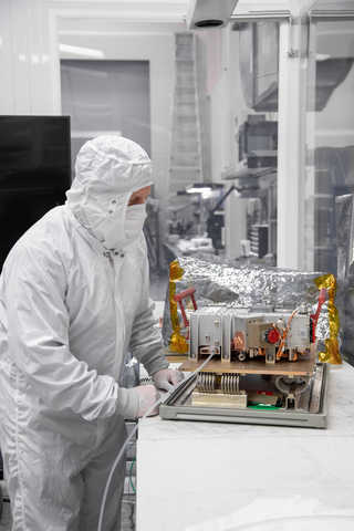 individual in full personal protective equipment standing with ultraviolet spectrograph
