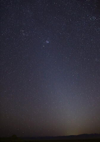 Zodiacal light in the sky above a dark horizon