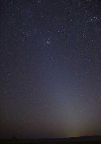 Zodiacal light in the sky above a dark horizon