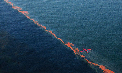 Airplane dropping dispersants on oil spill over water