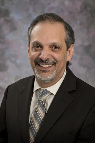 Professional portrait of Chris Sharp against a dark background