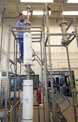 An SwRI engineer setting up equipment for fluidized bed pyrolysis