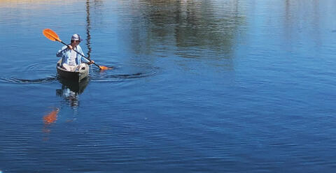 man in hat kayaking