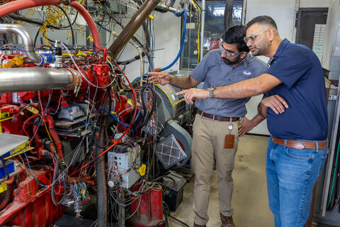 Two researchers studying pre-ignition in hydrogen engines in a lab