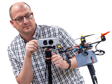 A man fixing an event camera to track small, fast and agile uncrewed aerial systems