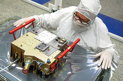 UVS instrument with red handles on a clean room table with an engineer standing by