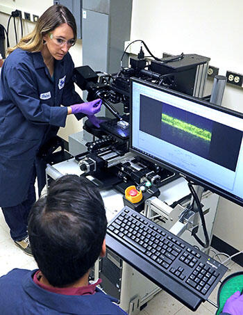 Black VASE tool sitting on a table with a computer screen and two researchers nearby