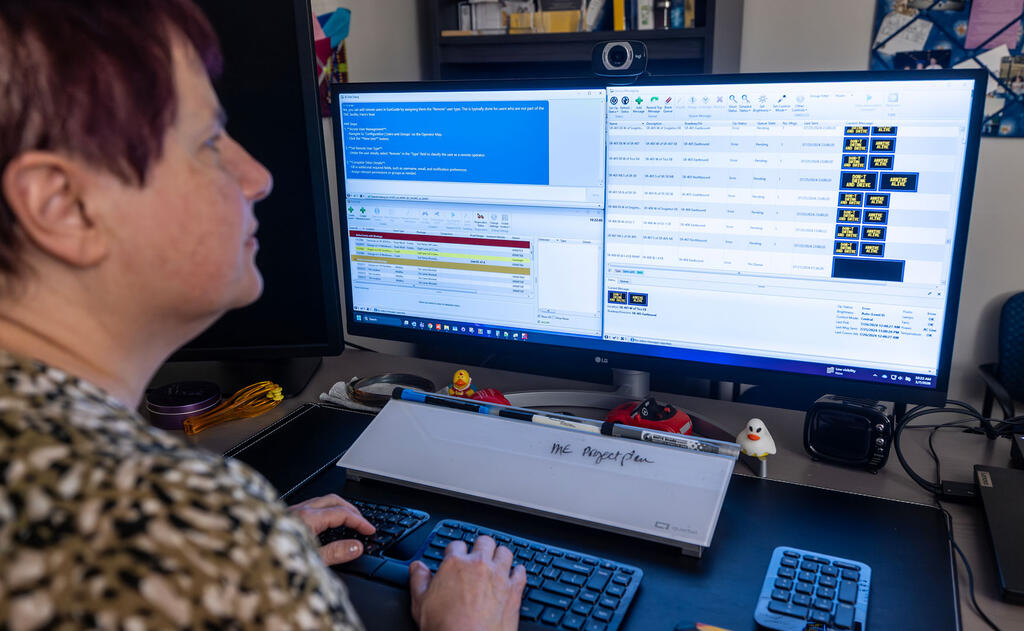 Woman looking at her computer screen using SwRI's LLM initiative chatbot for ITS technologies