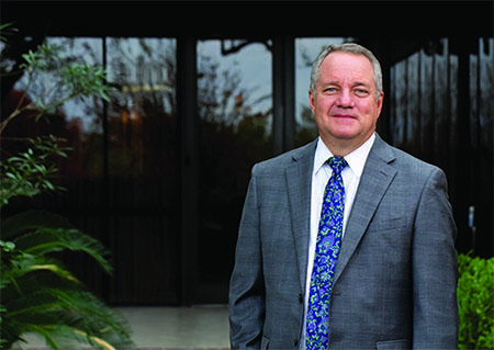 Adam Hamilton standing infront of the Administration Building on the Southwest Research Institute campus