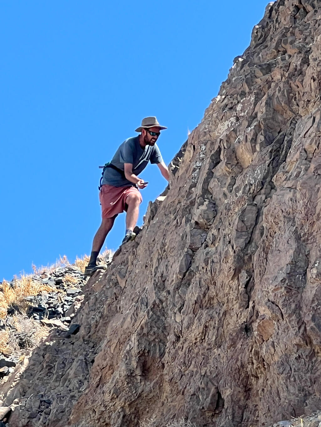 Adam Cawood climbing rock formations in Clayton Valley, NV