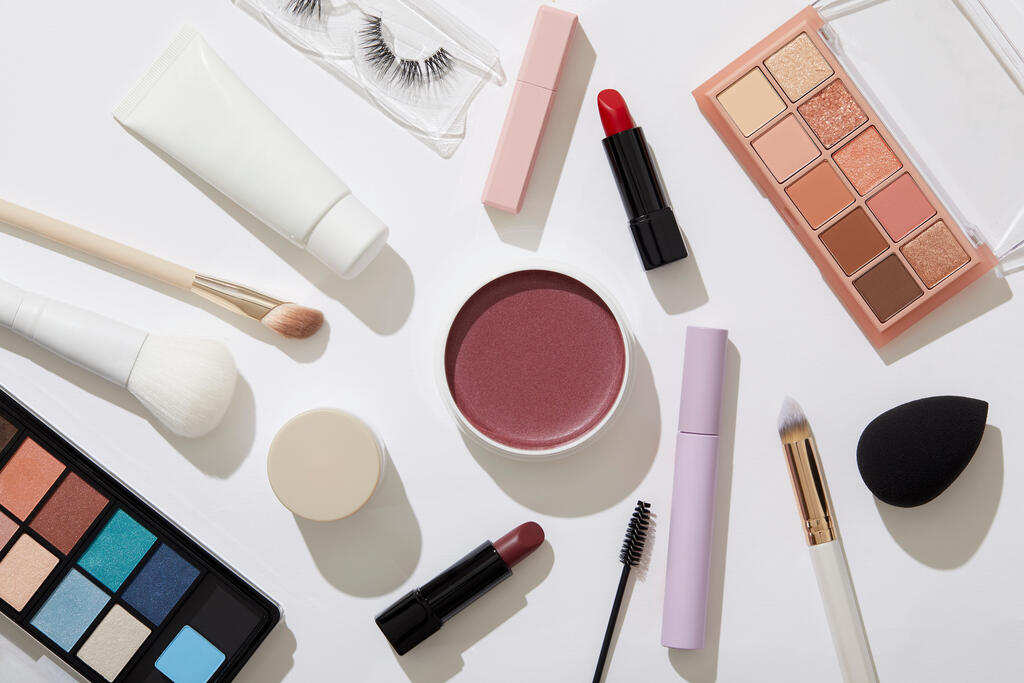 Overhead view of beauty and makeup products on white background 