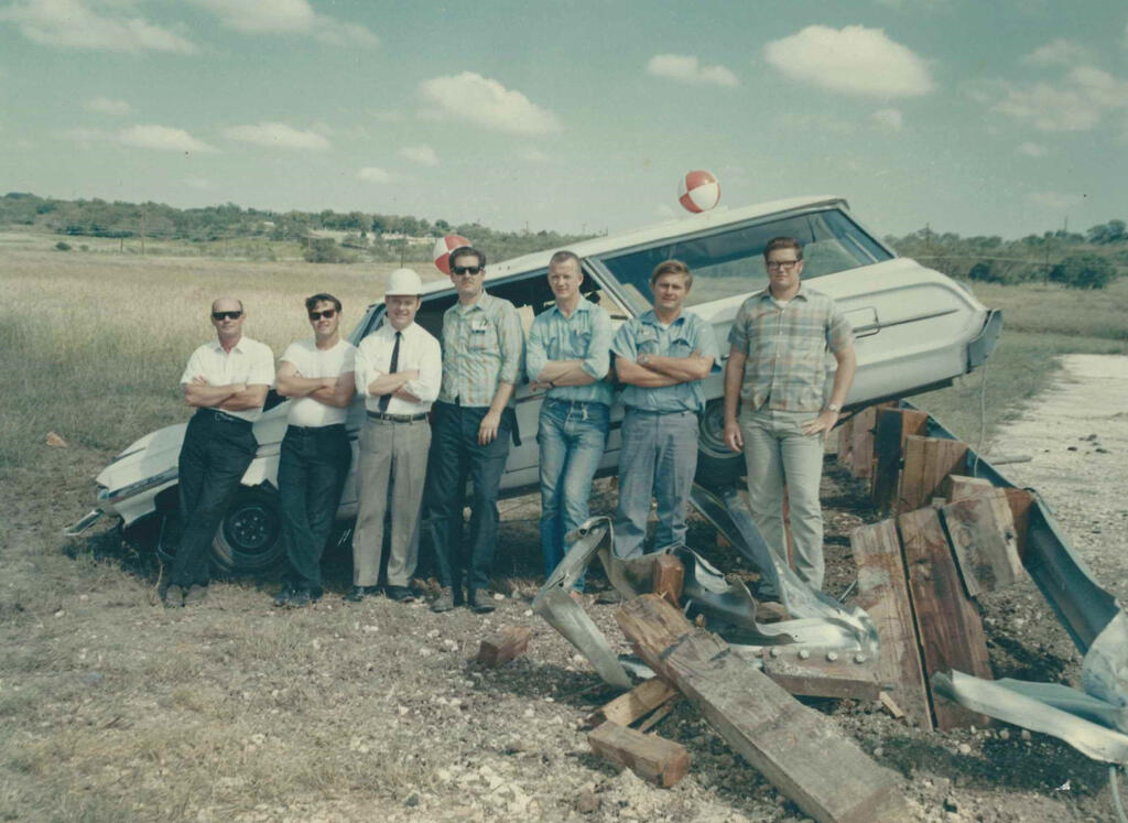 SwRI crash crew team in the late 1960s in front of a crashed car