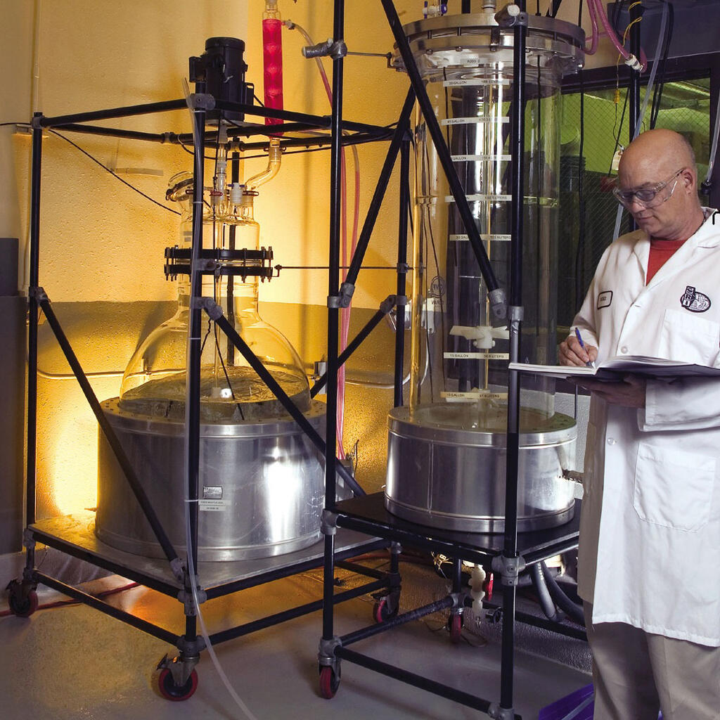 Technitian next to 200-liter reactor for synthesizing batches of pharmaceutical ingredients