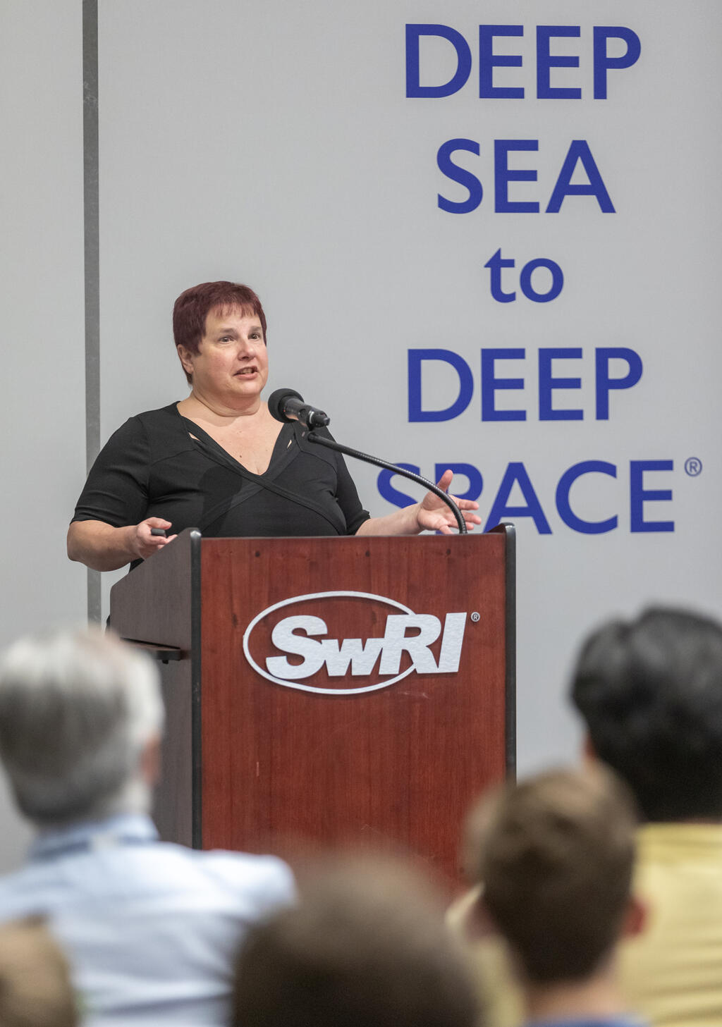 Lynne Randolph behind a podium speaking at SwRI