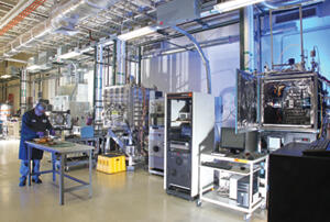 Scientist working in materials science laboratory containing vacuum chambers