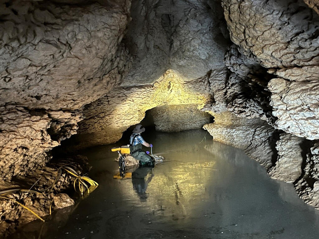 SwRI Research Scientist and Hydrologist Mauricio Flores samples water at the Phantom Lake Spring cave in west Texas