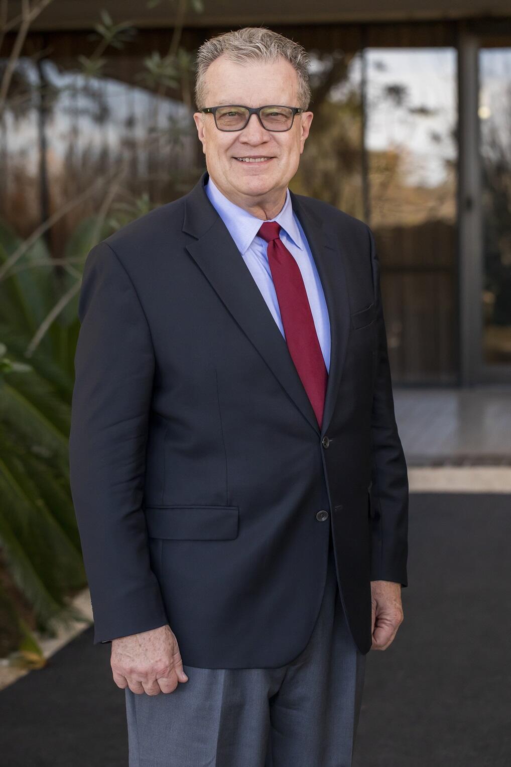 Walt Downing with a charcoal suit and red tie