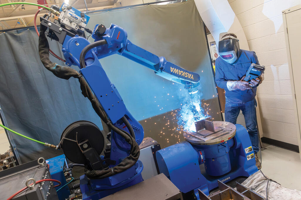 SwRI staff remote controlling welding robot at SwRI labs