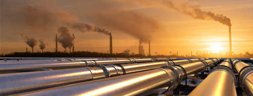 Pipelines leading to an oil refinery at sunset