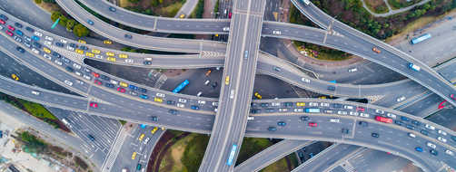 Aerial view of a freeway interchange with many cars on the road