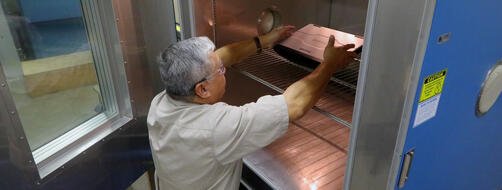 SwRI Principal Technician Michael Negrete places a laptop designed for rugged performance into a temperature/humidity chamber