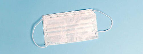 White face mask on light blue background