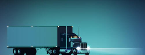 Big rig semi truck with headlights on against a teal blue background