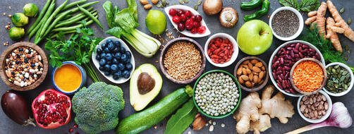 Variety of different fruits and veggies spread across a grey counter top. 