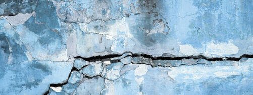 Peeling plastered wall with cracks