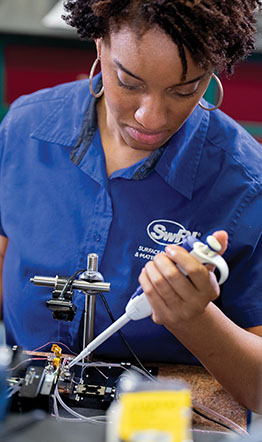 an engineer applying droplets of fluid onto a piece of machinery